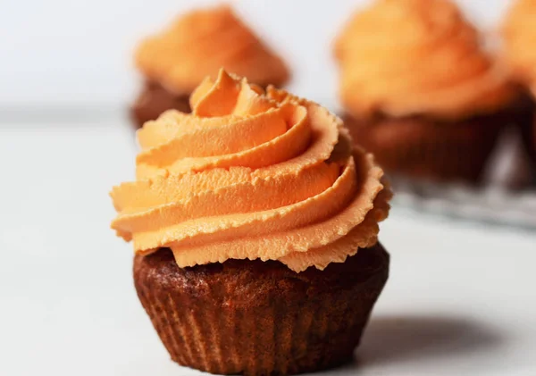 Fresh and tasty with orange frosting cupcakes on white background — Stock Photo, Image