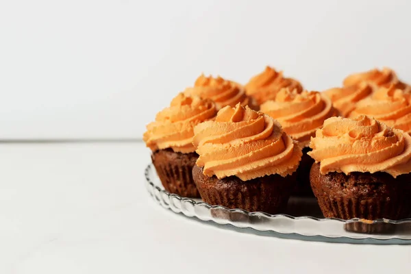 Frisch und lecker mit orange Zuckerguss Cupcakes auf weißem Hintergrund — Stockfoto