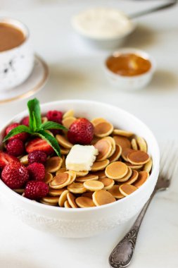 Beyaz arka planda tereyağı ve böğürtlenli mini gözleme gevreği. Moda Yemek Kahvaltısı Konsepti.