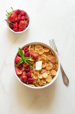 Beyaz arka planda çilekli ve nane yapraklı mini krep gevreği..