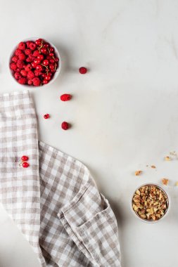 Beyaz bir masada kareli peçeteli böğürtlen ve fındık. Üst görünüm kopyalama alanı