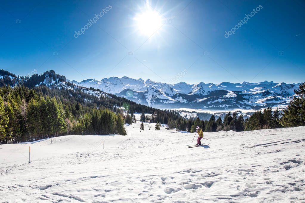 Skier riding in beautiful winter landscape picture. Skier skiing in Swiss Alps covered by snow. Ibergeregg, Switzerland, Europe. 