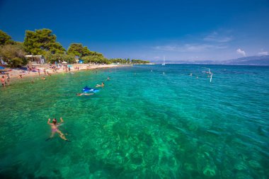 BRAC, CROATIA - August 6, 2018 - Pebble beach on Brac island with turquoise clear ocean water, Supetar, Brac, Croatia clipart