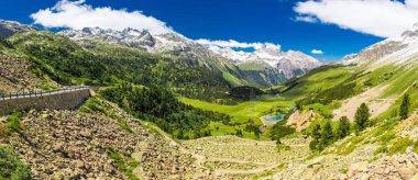 Albula'ya giden dağ yolu yeşil dağlık arazi ile geçerken, İsviçre.