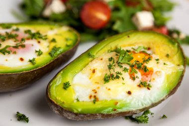 Maydanoz ve roket salata, domates ve peynir salatası ile serpilir yumurtalı kızarmış avokado