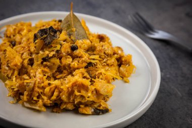 Bigos - lahana turşusu ile geleneksel Polonya yemeği ve et, pastırma ve mantarlı beyaz plaka üzerinde taze lahana