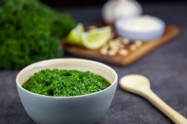 Pesto kale üzerinden. Kale, peynir, limon, çam fıstığı ve arka planda sarımsak