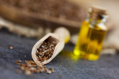Sağlıklı yağ - woden kaşık, keten tohumu ve arka planda bootle içinde keten yağı keten tohumu