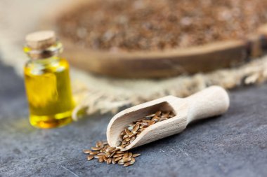Sağlıklı yağ - woden plaka üzerinde keten tohumu, keten tohumu yağı bootle içinde arka planda