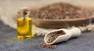 Sağlıklı yağ - woden plaka üzerinde keten tohumu, keten tohumu yağı bootle içinde arka planda