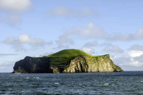 Bir küçük ev ile volkanik ada. Bjarnarey, Vestmannaeyjar, İzlanda