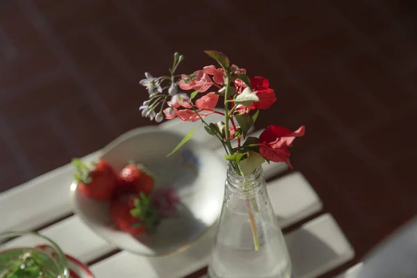 Silvester Çiçekler arka planda çilek ile beyaz bir masada. Narin vintage dekorasyon