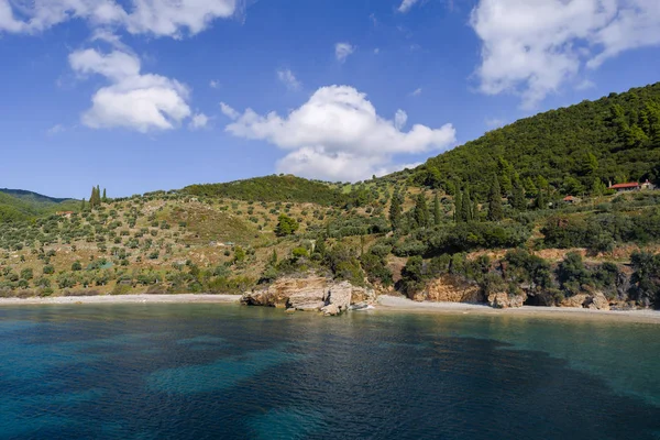 Bir sakin ve renkli sonbahar şeridi kaya oluşumları, yemyeşil bitki örtüsü ile yamaçlar ve görkemli bir gökyüzü.