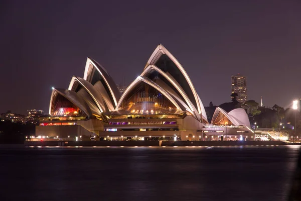 Sydney Opera Binası Geceleri Arka Planda Bina Şehir Ile Aydınlatılmış — Stok fotoğraf