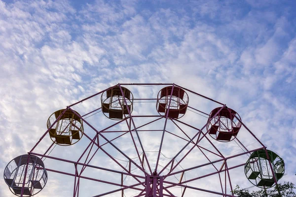 Ferris wheel without people over cloudy sky background