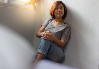 Sarılma diz katta oturan ve evde bir şey hakkında düşünüyor genç kadın.