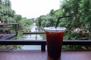 Buz siyah kahve ya da muz çiftliği soğuk içecek yaz için arka planda olan plastik kap içinde uzun siyah kahve