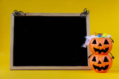 Halloween Jack o fener kova ve sarı zemin üzerine boş yazı tahtası