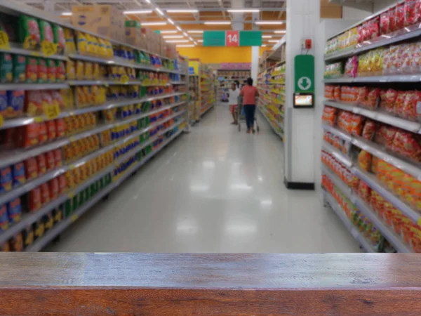 Boş ahşap masa üstü ürünleri raflarda Snack yelpazesi raf süpermarket veya mağaza, alışveriş bulanık insanlar üzerinde