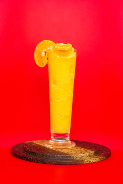 Smoothie orange sain en verre aux fruits orange sur fond rouge — Photo