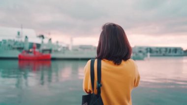 Daring Harbor Sydney, Avustralya 'da Asyalı kadın turist savaş gemilerinin fotoğraflarını çekiyor.