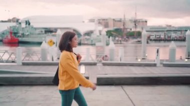 Asya 'lı turist gün batımında Daring Harbor Sydney, Avustralya' da yürüyüşe çıkıyor.