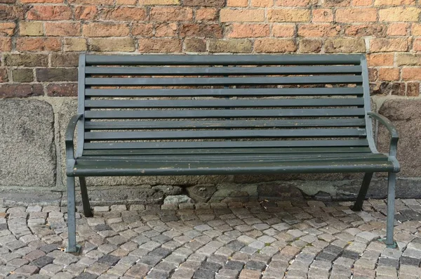 Malmo, İsveç'in eski şehir kaldırım taşı kaldırım üzerinde ahşap Bank. 