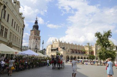 Kracow, Polonya - 25 Temmuz 2018: Main Market Square City Hall Tower ve arka planda, Krakow, Polonya bina Cloth Hall, at arabası.