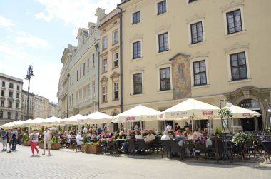 Krakow, Polonya - 26 Temmuz 2018: İnsanlara Restoran teraslar ana kare Krakow, Polonya.