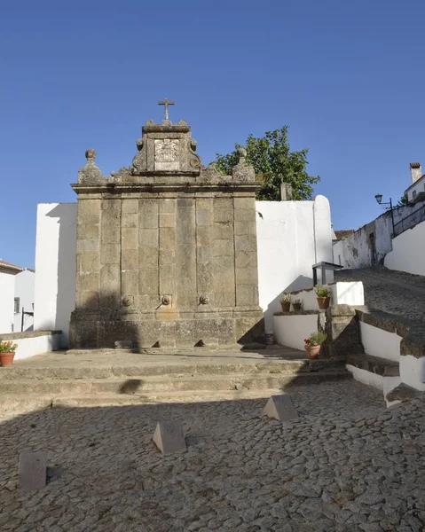 Stone fountain at cobbled plaza — Stock Photo, Image