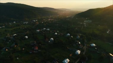 Kamera köyü güneş doğarken yavaş yavaş uçar. Karpat Dağları. Yaz. Havadan görüntüleri.