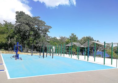 arka plan beyaz bulutlar ve yeşil ile mavi gökyüzünün altında açık spor zemin ağaçlarının yaprakları