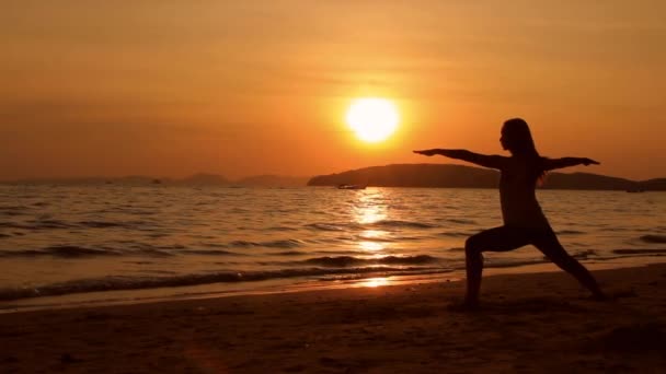 日落时分在海滩上表演瑜伽的女人 — 图库视频影像