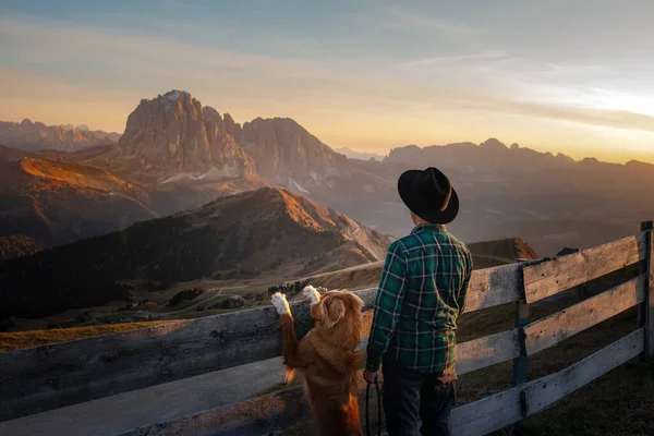 Ein Mann mit Hund. Reisen mit einem Haustier. Dolomiten Alpen. Wandern, entspannen. — Stockfoto