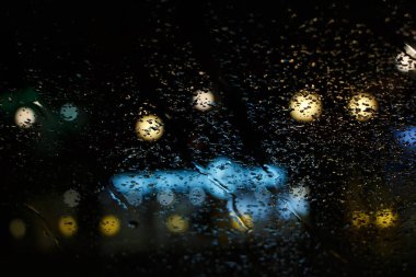 Yağmurlu gece ve sokak ışık cam pencere arkasında. Yağmur damlası pencere ve bokeh arka plan soyut bulanıklık.