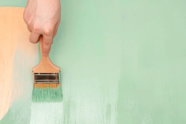 Ahşap yüzeylere boya fırçası kullanarak yeşil boya ile boyama