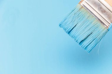 Bir boya fırçası kullanarak mavi boya ile ahşap yüzey boyama