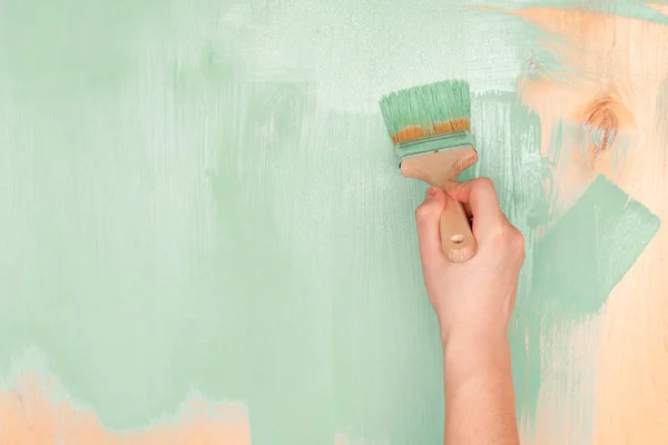 Erkekler el boya ahşap yüzey ile yeşil boya boya b kullanarak