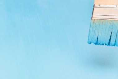 Bir boya fırçası kullanarak mavi boya ile ahşap yüzey boyama