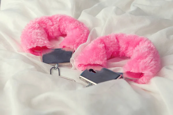 Beyaz kumaş arka plan üzerinde kabarık pembe kelepçe