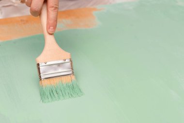 Ahşap yüzeylere boya fırçası kullanarak yeşil boya ile boyama