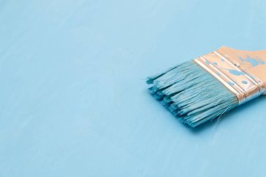 Bir boya fırçası kullanarak mavi boya ile ahşap yüzey boyama