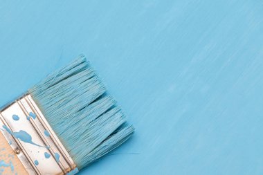 Bir boya fırçası kullanarak mavi boya ile ahşap yüzey boyama