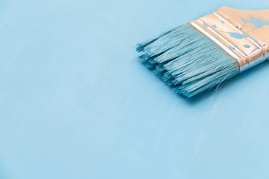 Bir boya fırçası kullanarak mavi boya ile ahşap yüzey boyama