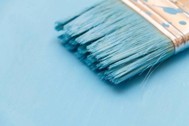 Bir boya fırçası kullanarak mavi boya ile ahşap yüzey boyama