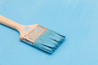 Bir boya fırçası kullanarak mavi boya ile ahşap yüzey boyama