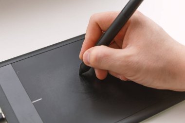 Erkekler el bir kalemi kullanarak bir grafik tablet üzerinde çizer