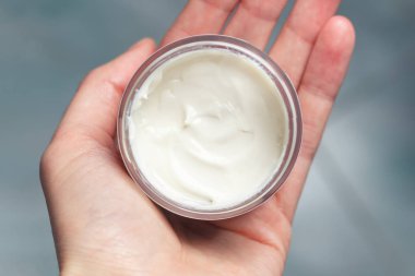 Kadın el kremi bir kavanoz tutarak