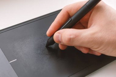 Erkekler el bir kalemi kullanarak bir grafik tablet üzerinde çizer