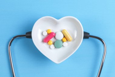 Steteskop ve çeşitli hap bir daire üzerinde kalp şeklinde bir